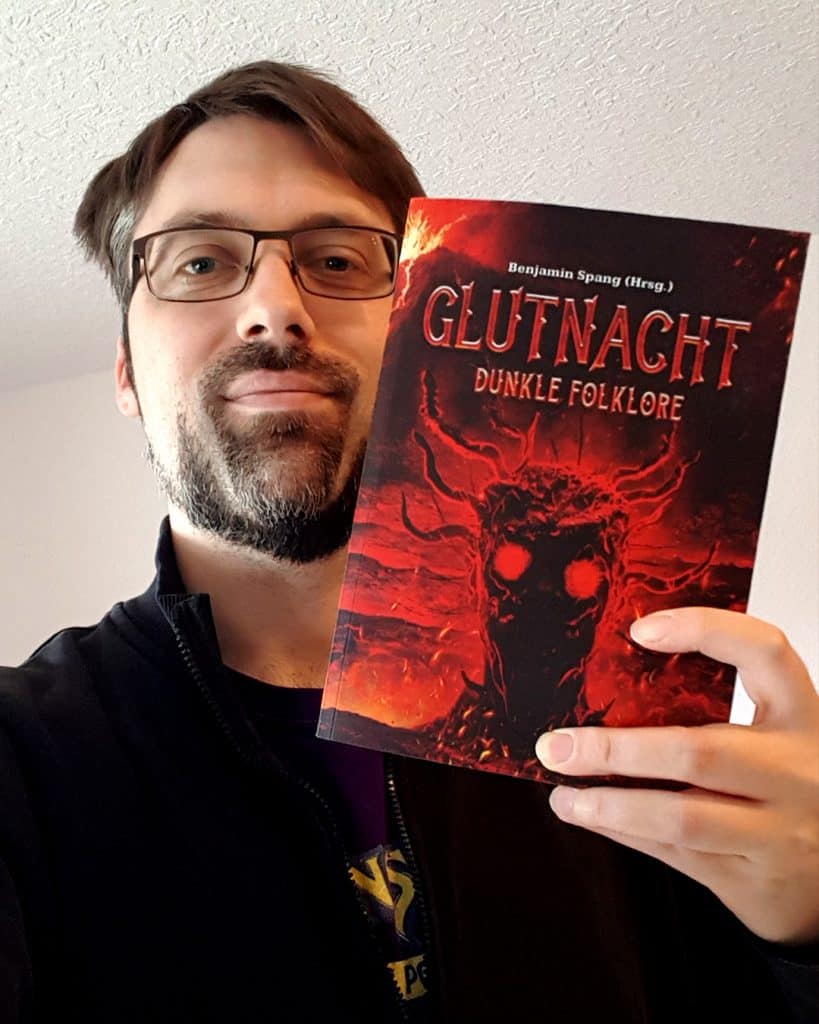 Benjamin Spang mit der Anthologie "Glutnacht: Dunkle Folklore", die er als Herausgeber veröffentlicht hat